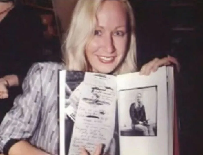 Blonde woman holding open book with handwritten notes, part of eerie web mysteries