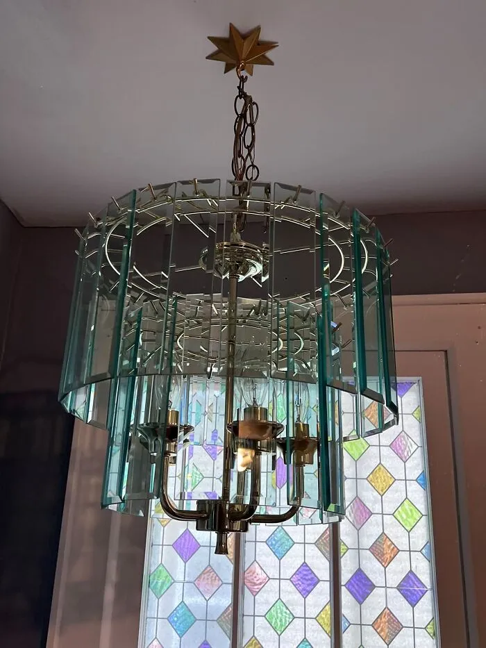 Wonderful thrift finds like this vintage tiered glass panel chandelier hanging near a stained glass window.