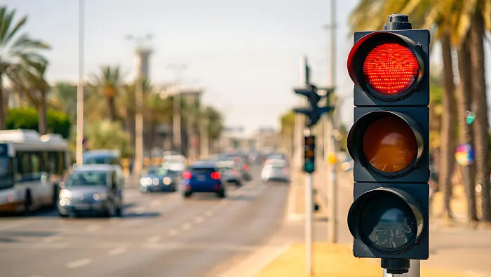 A red traffic light on a city street illustrating emergency tips for road safety.