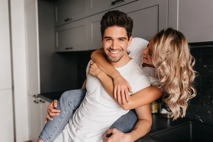 Happy couple hugging playfully in kitchen