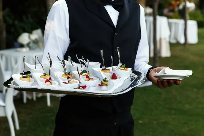 A waiter carrying a tray of snacks, related to obvious lies.