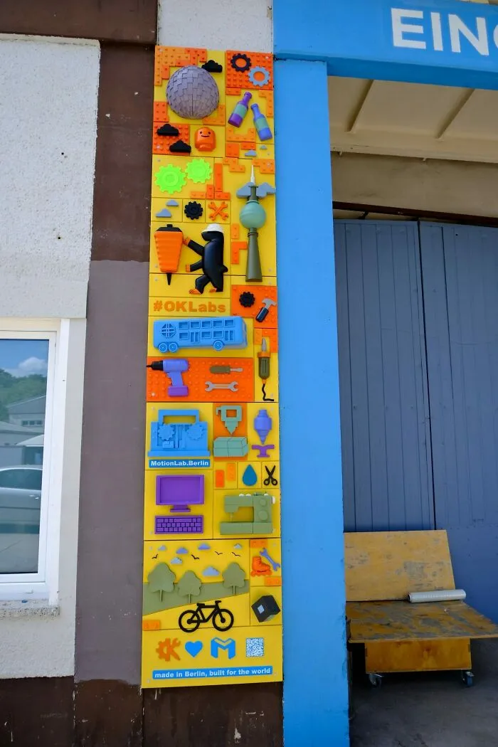 Colorful LEGO brick art collective installation on a building facade on city streets