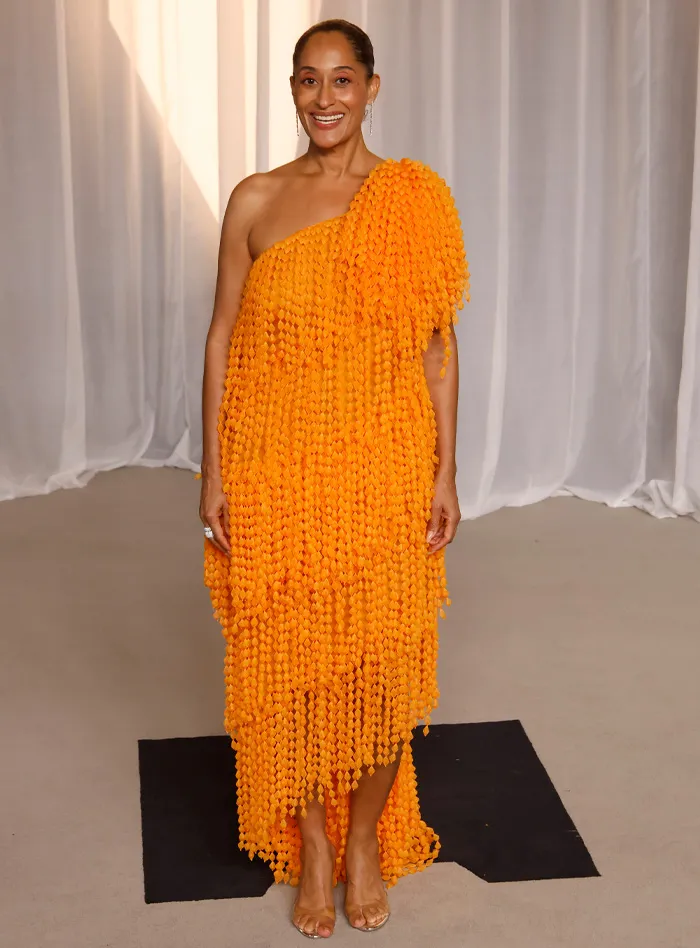 Woman in one-shoulder orange dress at Academy Museum Gala