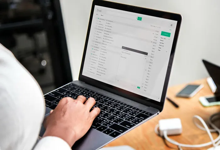 Person accessing email inbox on laptop keyboard