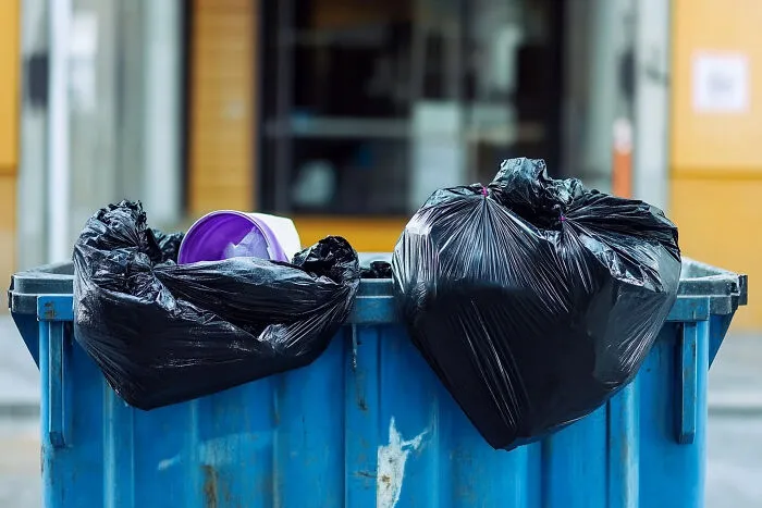 Black garbage bags in a blue bin, illustrating a creepy moment involving things strangers said.