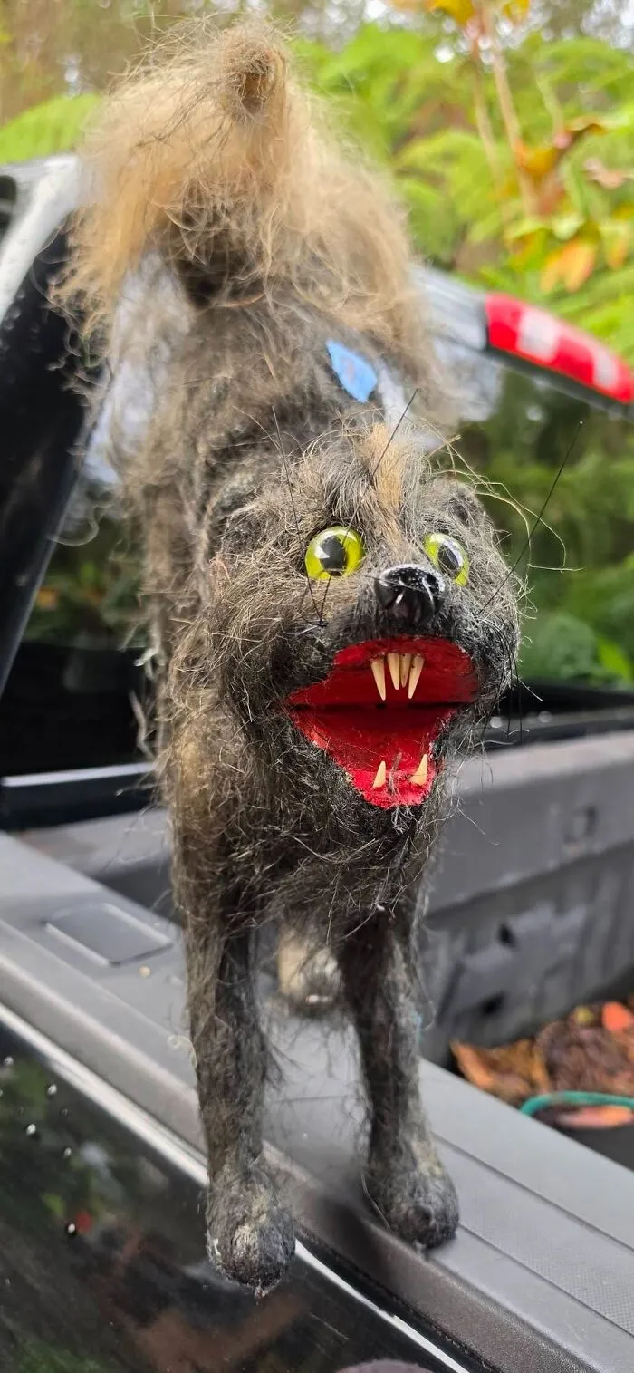 A strange fuzzy creature figurine with sharp teeth and yellow eyes discovered as weird thrift finds.