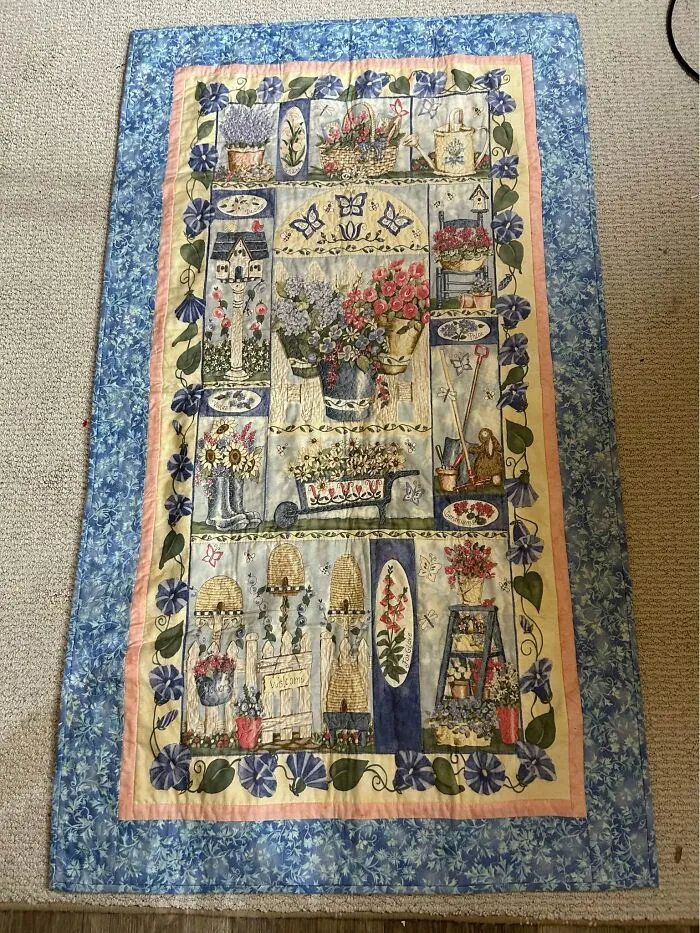 Quilted wall hanging or blanket with garden and flower motif in blue tones
