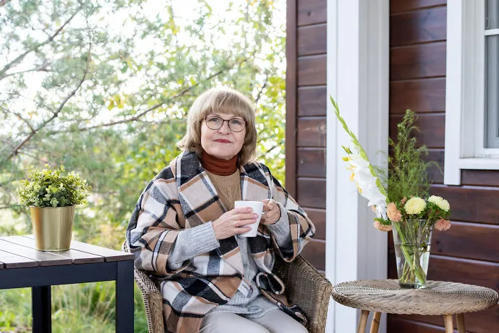 A woman sitting outdoors holding a mug, illustrating how strangers said unsettling things.