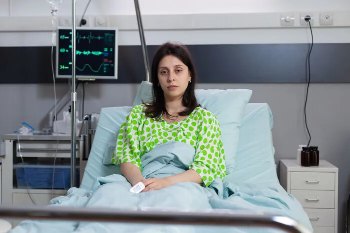 A sad woman sitting in a hospital bed representing difficult divorce stories.
