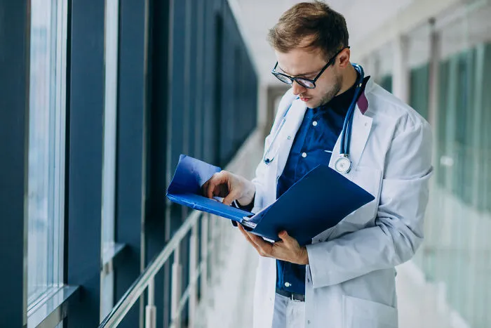 Doctor looking through files, illustrating complex emotional hardship in personal divorce stories.