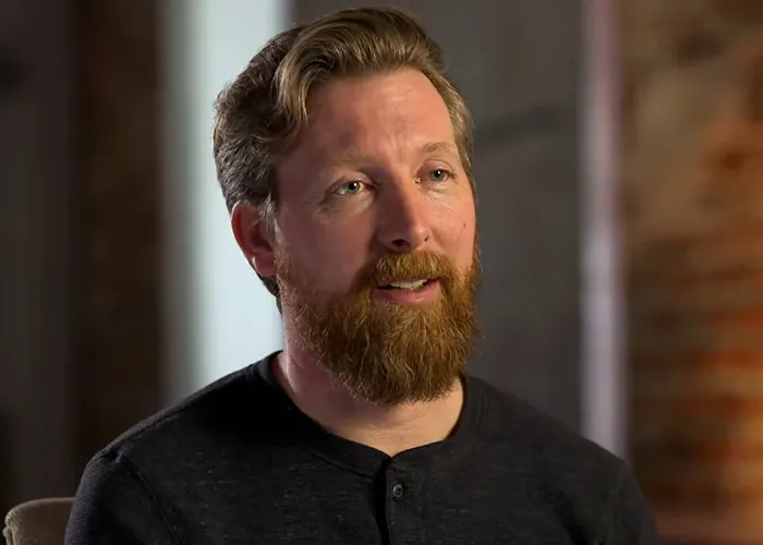 A bearded man featured in true crime stories discussing an investigation