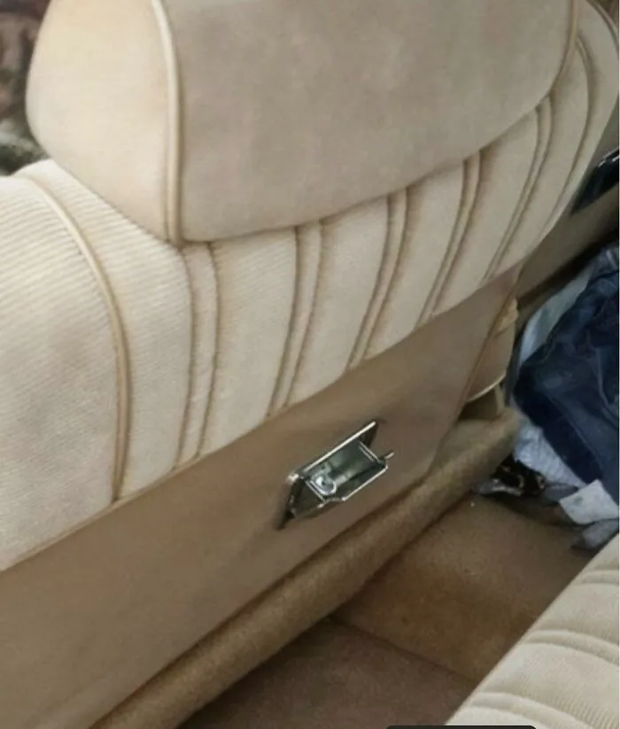 The back of a plush vintage car seat featuring a built-in metal ashtray from 80s kids memories.
