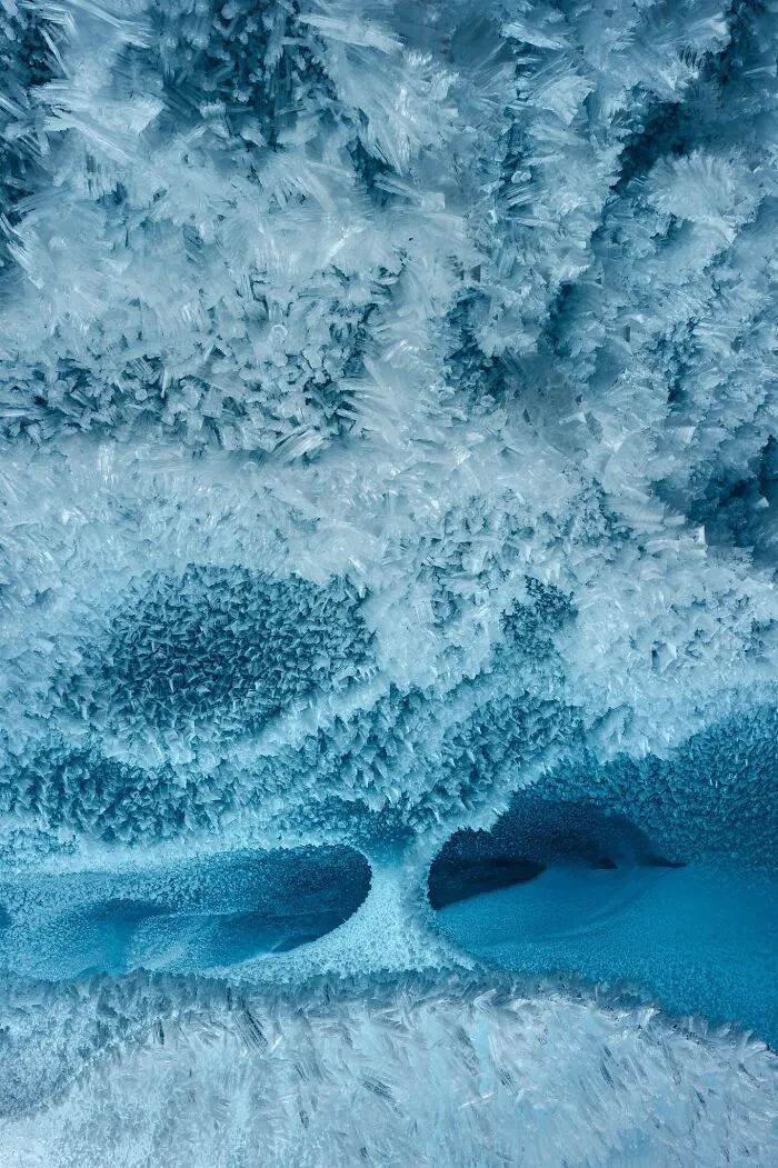 Detailed close-up of icy frost structures in a cool blue natural landscape photograph.