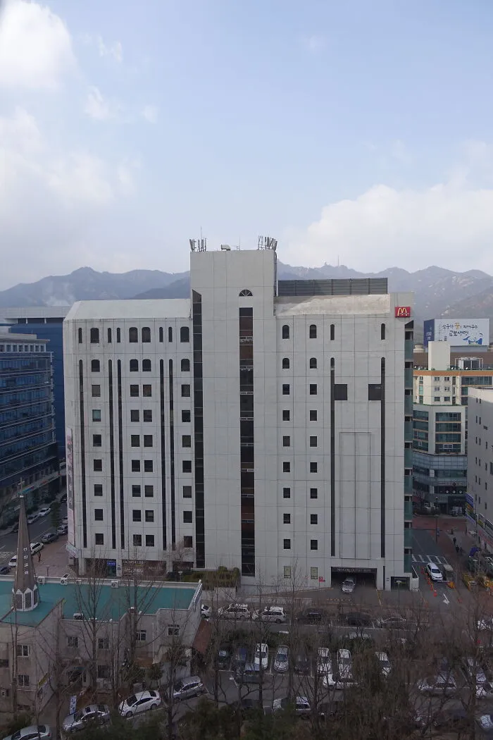 Aerial view of a large white city building associated with active cults.