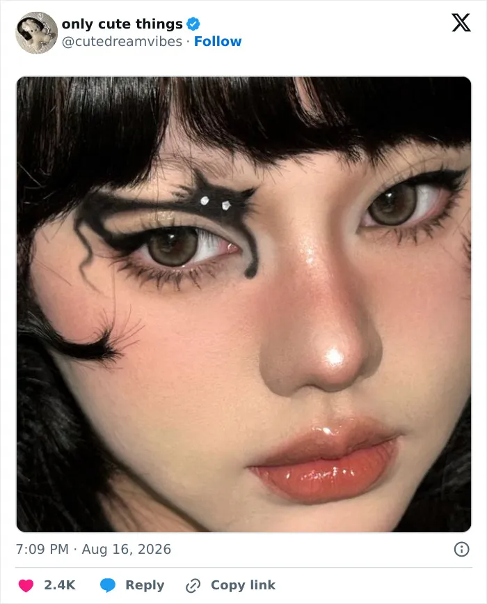 Close-up of artistic eye makeup with black cat design on eyelids