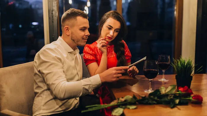 Couples seated at a restaurant table, reflecting on whether to skip a second date