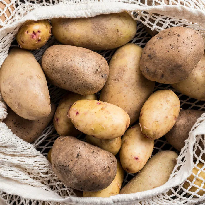 A mesh bag filled with raw potatoes related to questioning partner's culinary intelligence