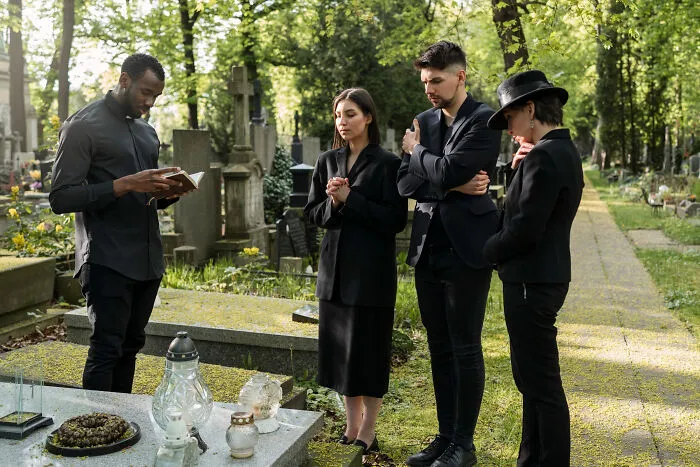 Group mourning at graveyard reflecting on obvious lies
