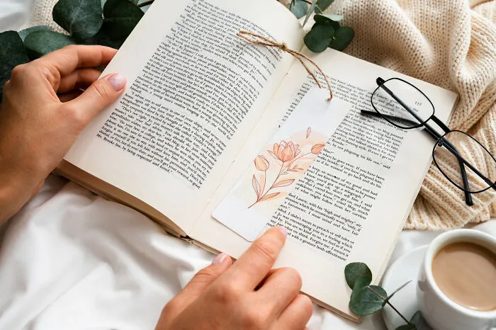 A person reading an open book with a floral bookmark, evoking intense fight-or-flight moments triggered by words