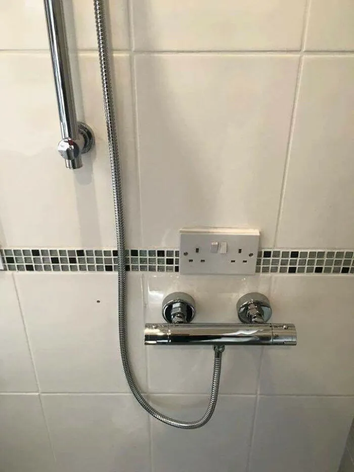 An electrical outlet installed dangerously close to a shower fixture, showing a risky effort to improve their homes.