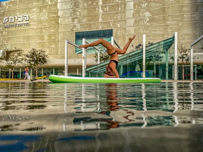 Woman doing yoga on paddleboard in water taken with iPhone photography