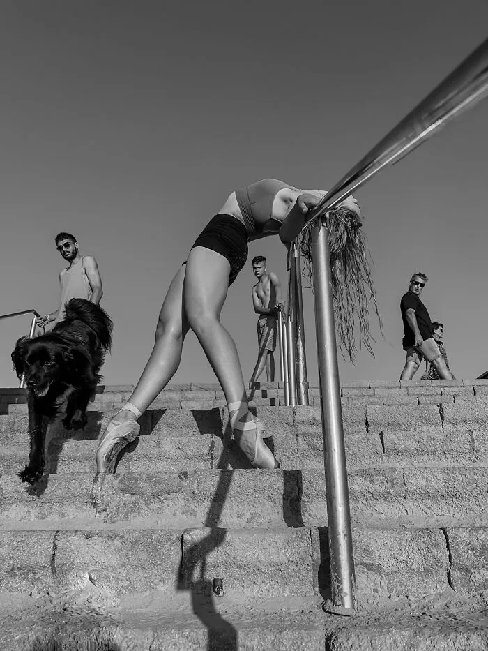 Ballerina stretching on railing with dog in iPhone photography