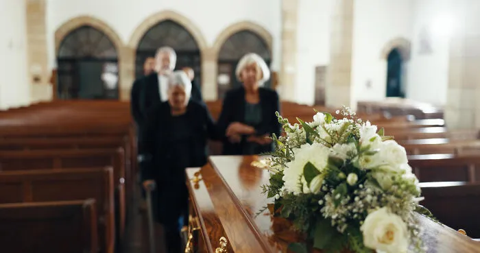 Coffin with flowers at funeral representing obvious lies