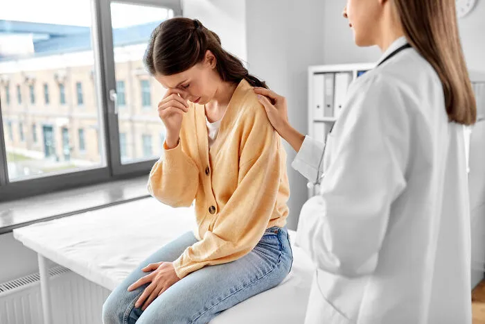 Female doctor comforting upset woman in medical office