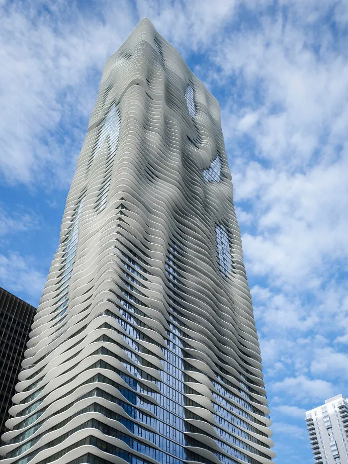 High-rise building featuring organic flowing balconies against blue sky