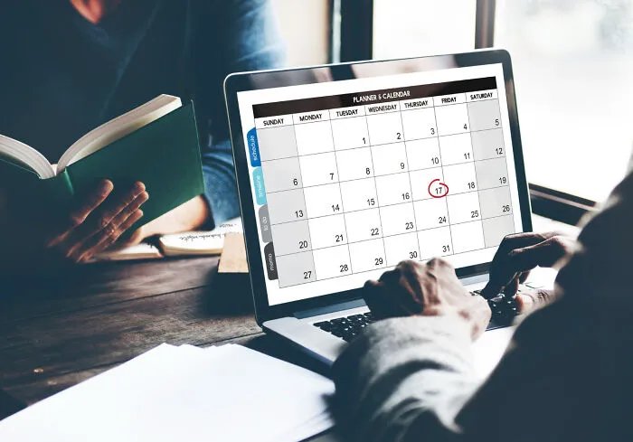 Person using laptop calendar with date circled for planning to get back at an ex