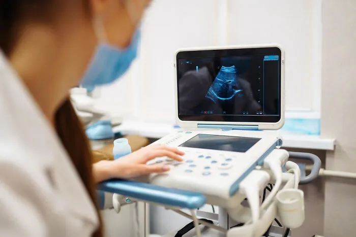 A medical professional performing an ultrasound scan for a sick patient