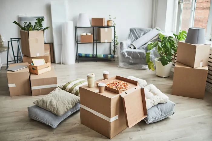 A room packed with moving boxes and pizza during real-life divorce stories packing