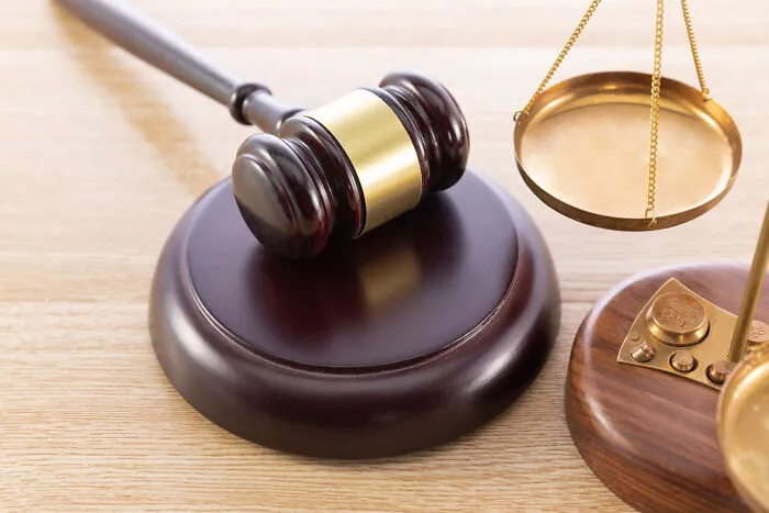 Wooden gavel and brass scales of justice representing legal proceedings in divorce stories.