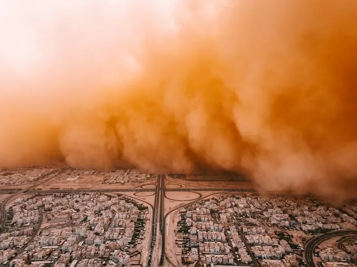 Massive dust storm approaching a city from above, captured for the Siena Drone Photo Awards.