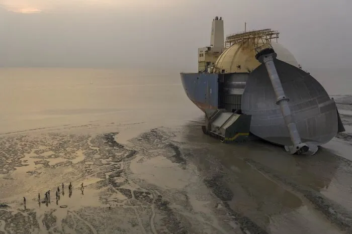 Massive decommissioned ship resting on a muddy shore from the 2026 Siena Drone Photo Awards collection.