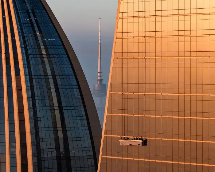 High-rise window washers suspended between skyscrapers, a entry in the 2026 Siena Drone Photo Awards.