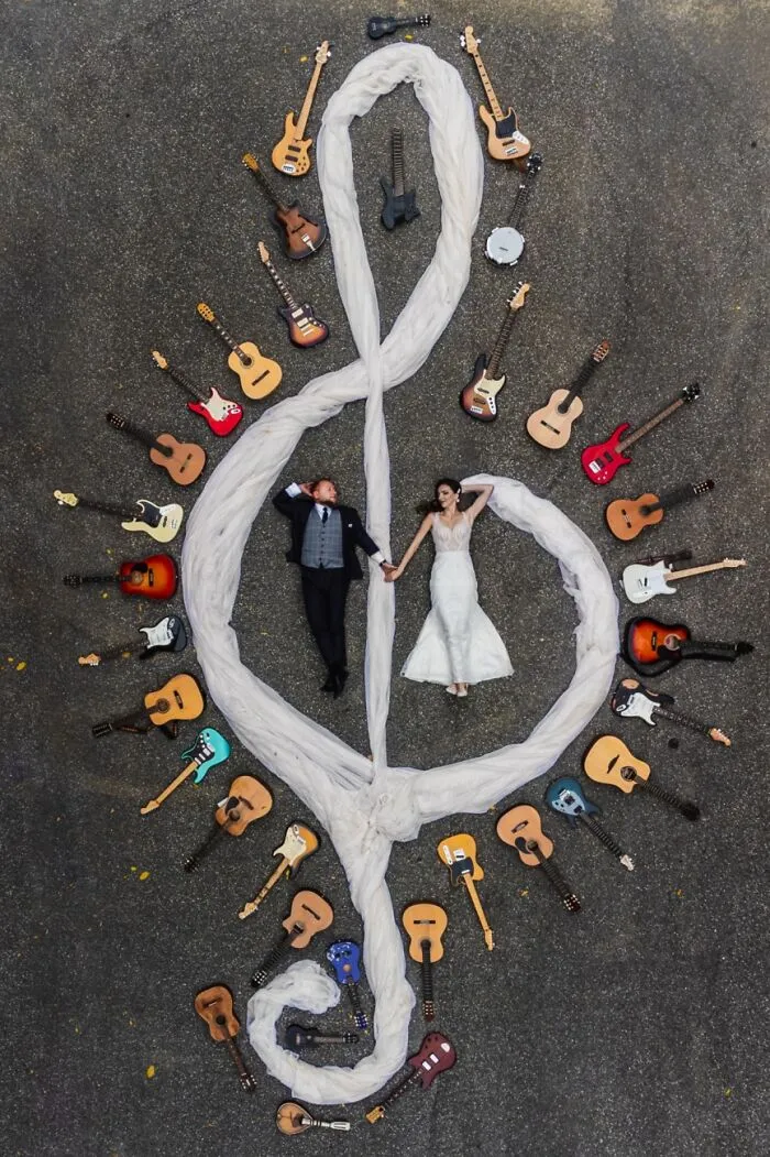 Overhead shot of a couple surrounded by guitars forming a treble clef, featured in the Siena Drone Photo Awards.