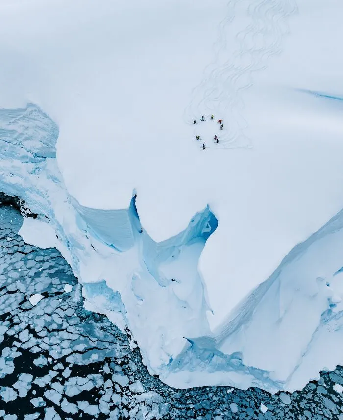 Aerial view of skiers on a snowy mountain top, an entry in the Siena Drone Photo Awards.
