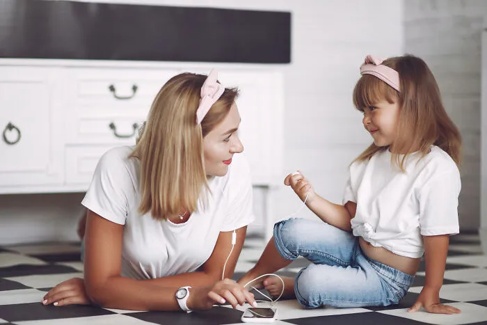A mother and daughter sharing a smartphone while learning life-saving emergency tips.