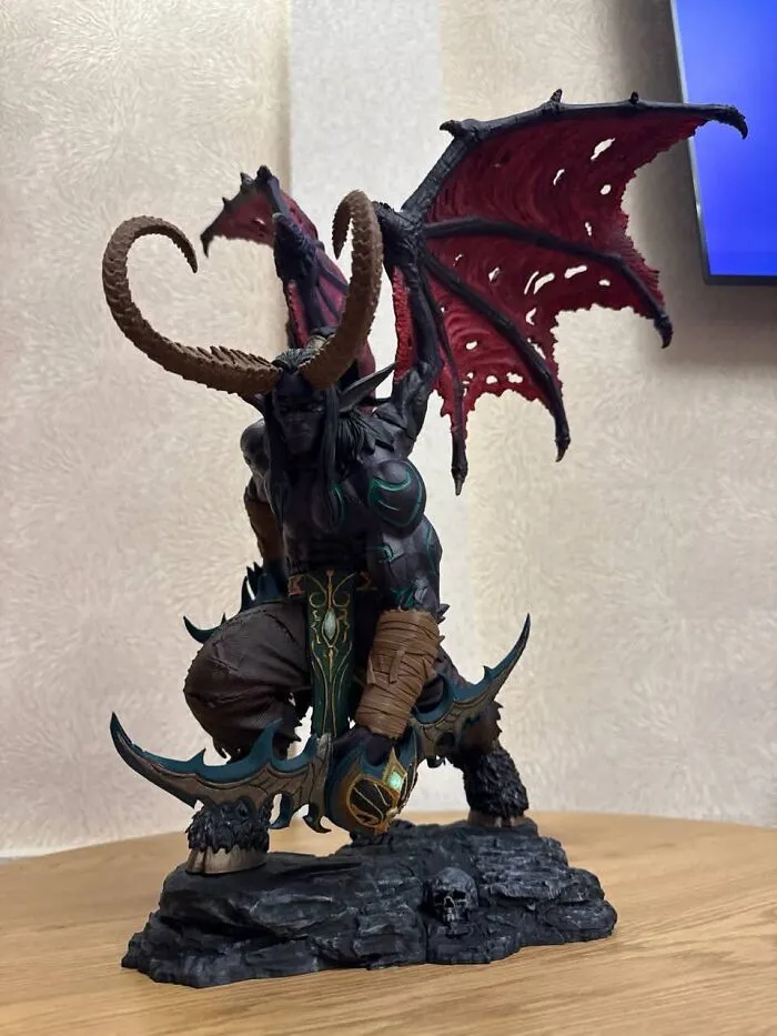 Detailed 3D prints of a fantasy demon figure with red wings holding a sword.