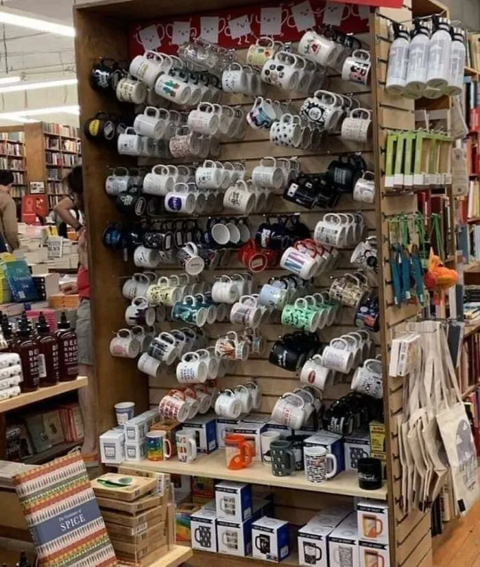 Display rack of mugs in a store creating a perfectly confusing illusion of a floating shelf layout.