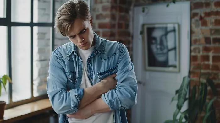 Young man looking down in distress while clutching his chest, symbolizing rising health problems in Gen Z.