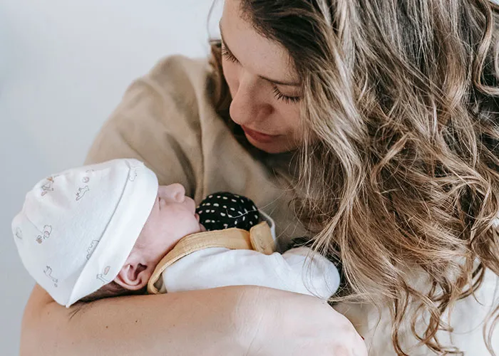 A mother lovingly holding her sleeping baby in her arms during new motherhood