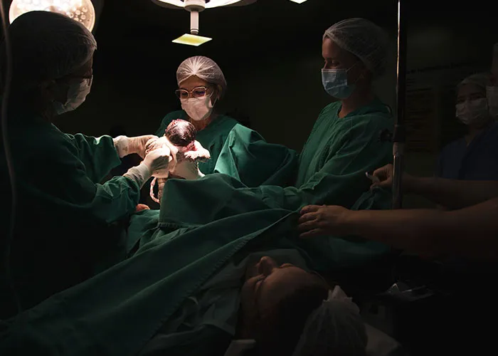 Medical team performing a C-section delivery, depicting the intense experience of giving birth in a hospital setting
