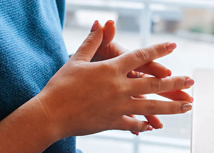 Close-up of a person wringing their hands nervously, symbolizing anxiety in new motherhood.