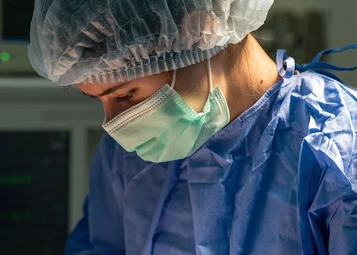 A healthcare professional wearing surgical gear, representing assistance during giving birth.