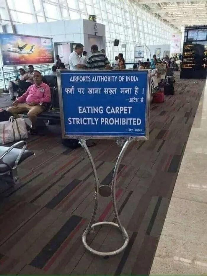 Airport sign displaying translation fails with text reading Eating Carpet Strictly Prohibited.