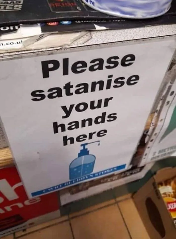 Hand sanitizer station sign with hilarious translation fails asking to Please satanise your hands here.