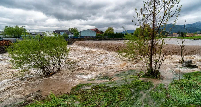 Rushing floodwaters near a town, representing scariest true stories.