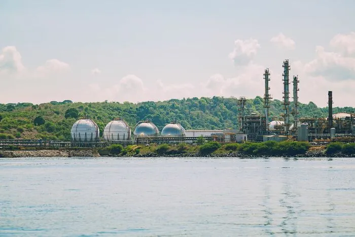 An industrial refinery complex by the water, looking like an abandoned backdrop for scariest true stories